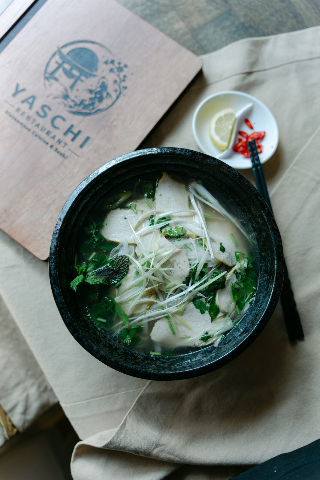 Phở Suppe mit Reisbandnudeln und frischen Kräutern