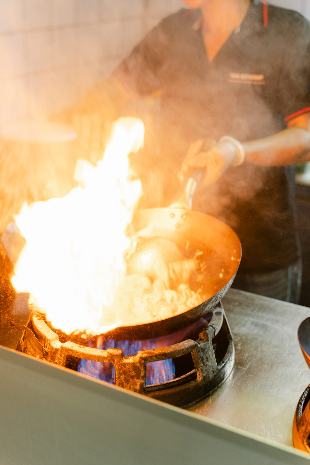 Wok mit offener Flamme in der Küche